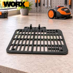 Black perforated plastic size S plate on workbench for robotic lawn mower accessory